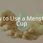 A clear menstrual cup held in clean hands, soft pink background, realistic and hygienic, modern feminine care product.